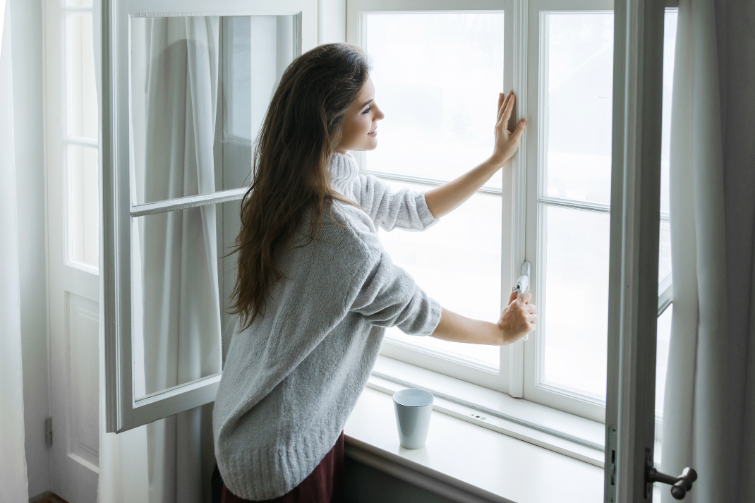 Γυναίκα κλείνει το παράθυρο για την προστασία των πνευμόνων